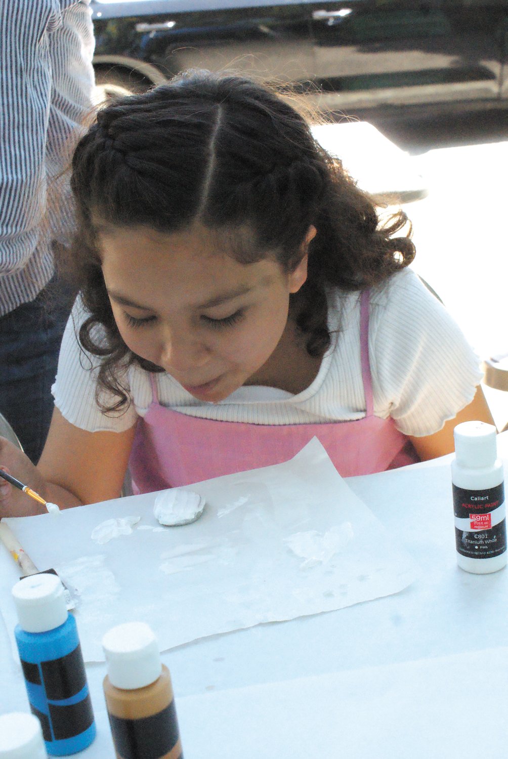 ROCKING AND ROLLING: Lex Hernandez, 10, blows on her newly painted rock to try and dry it so she can add another coat of paint at Oaklawn Library.